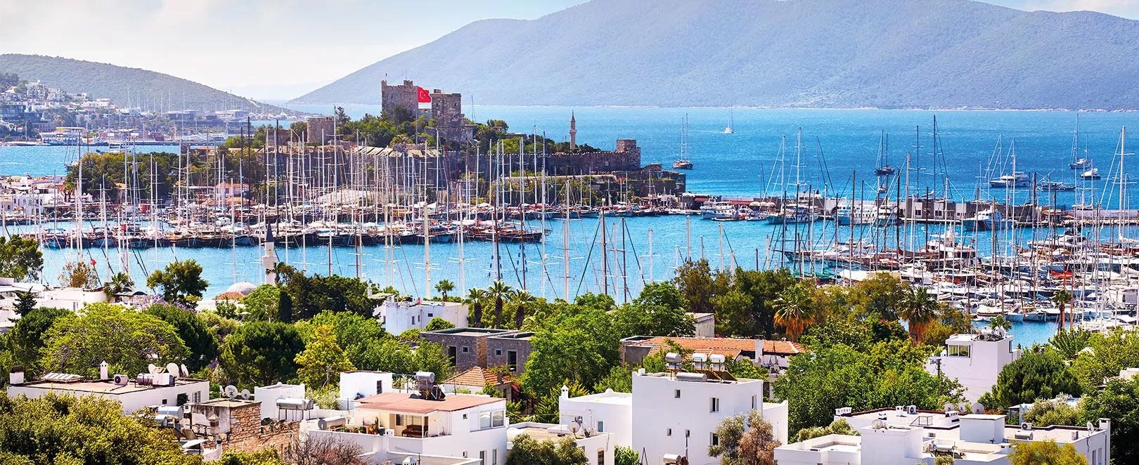 Vue générale de Bodrum avec marina et collines, station balnéaire prisée de la mer Égée en Turquie.