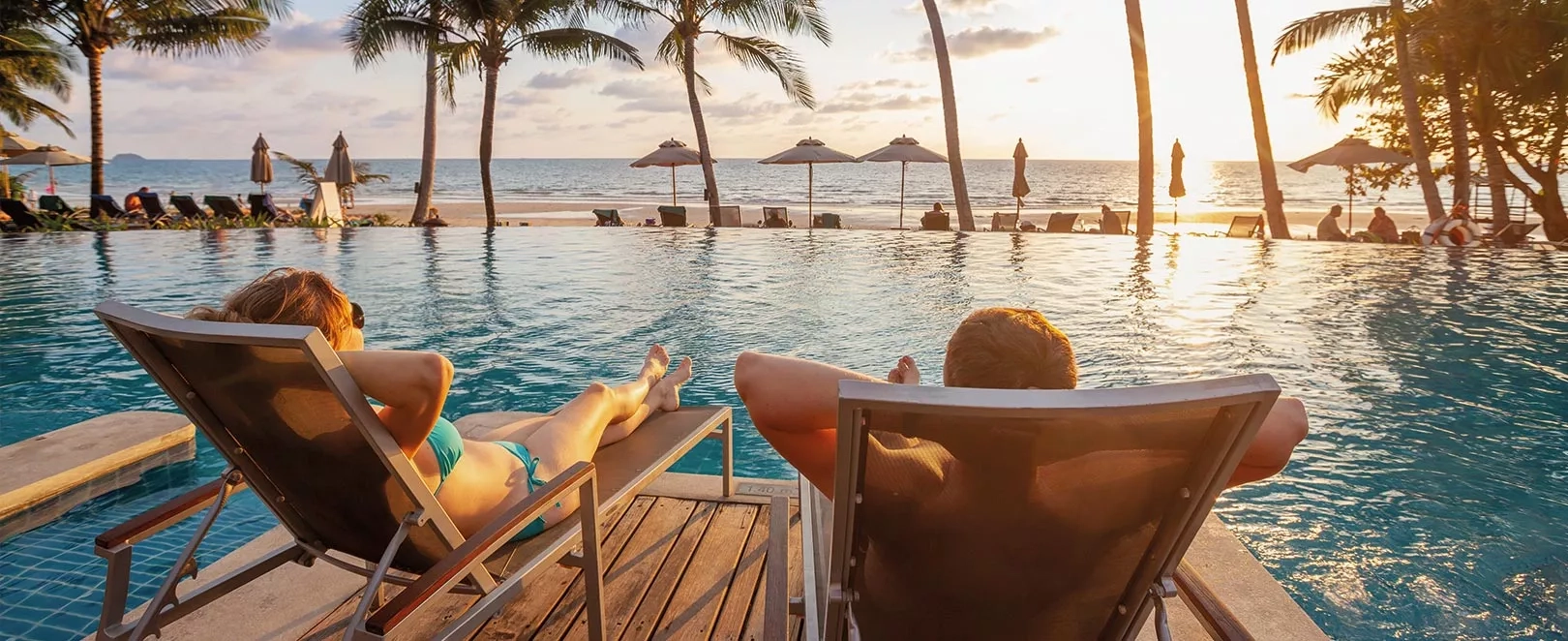 Couple au bord d'une piscine au soleil couchant