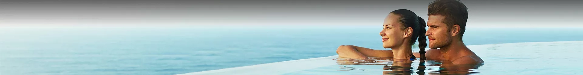 un couple dans une piscine regardant la mer