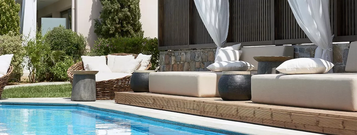 piscine et fauteuils en blanc à l'extérieur de l'hôtel avec végétation