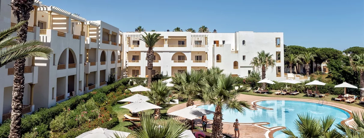 Zone piscine aménagée devant bâtiment hôtelier