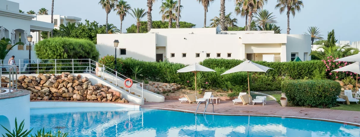 Bâtiments blancs autour d’une piscine calme
