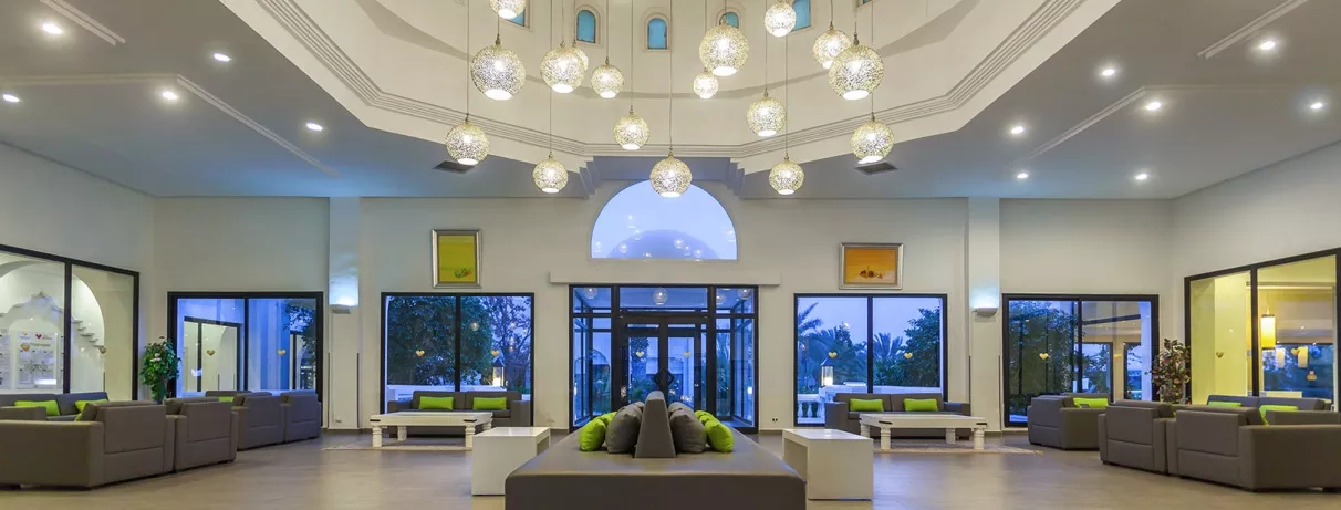 Hall d'accueil moderne avec lustres design et dôme oriental au sein de l'hôtel Djerba Aqua Resort.