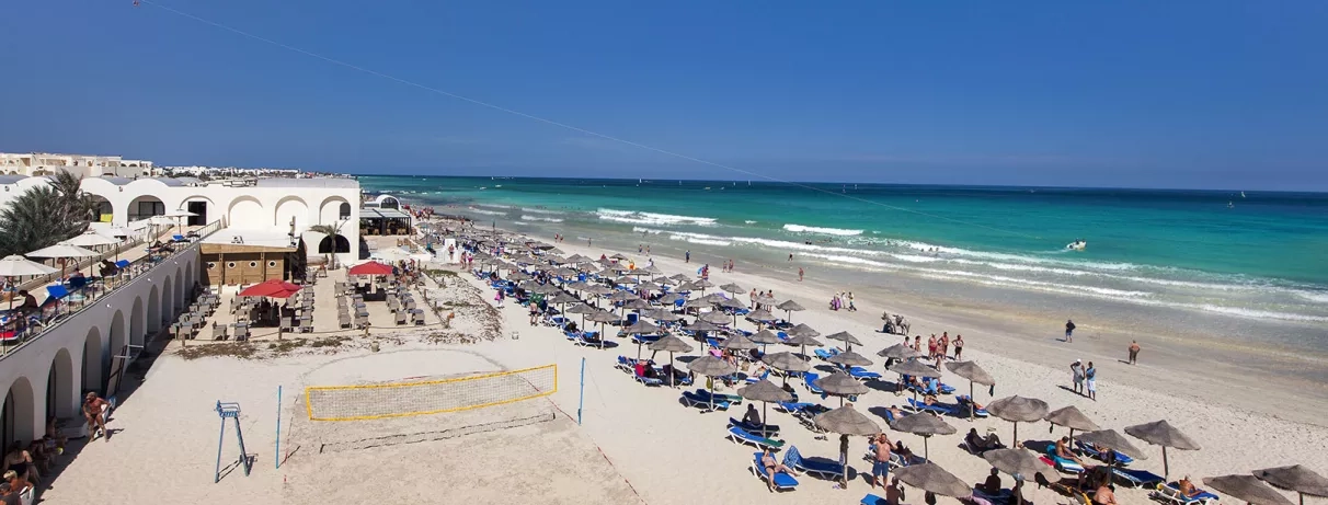 Plage de sable fin et mer turquoise au Djerba Beach, destination balnéaire prisée en Tunisie.