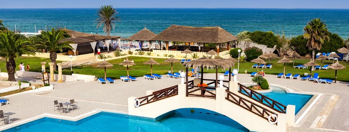 Piscine extérieure dotée d’un petit pont, offrant une vue dégagée sur la mer