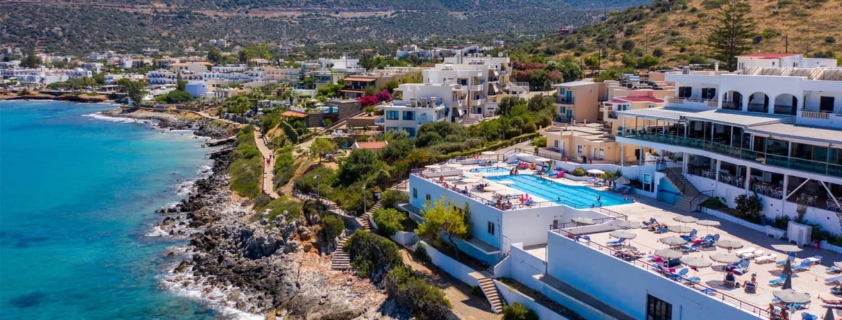 vue aérienne de l'hôtel donnant sur les rochers et la plage, la piscine et le bâtiment