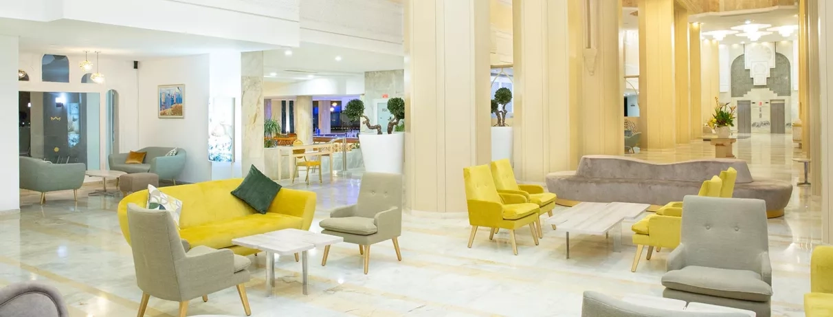 Lobby spacieux et moderne de l'hôtel Marhaba Palace avec canapés colorés, idéal pour un séjour détente à Monastir.