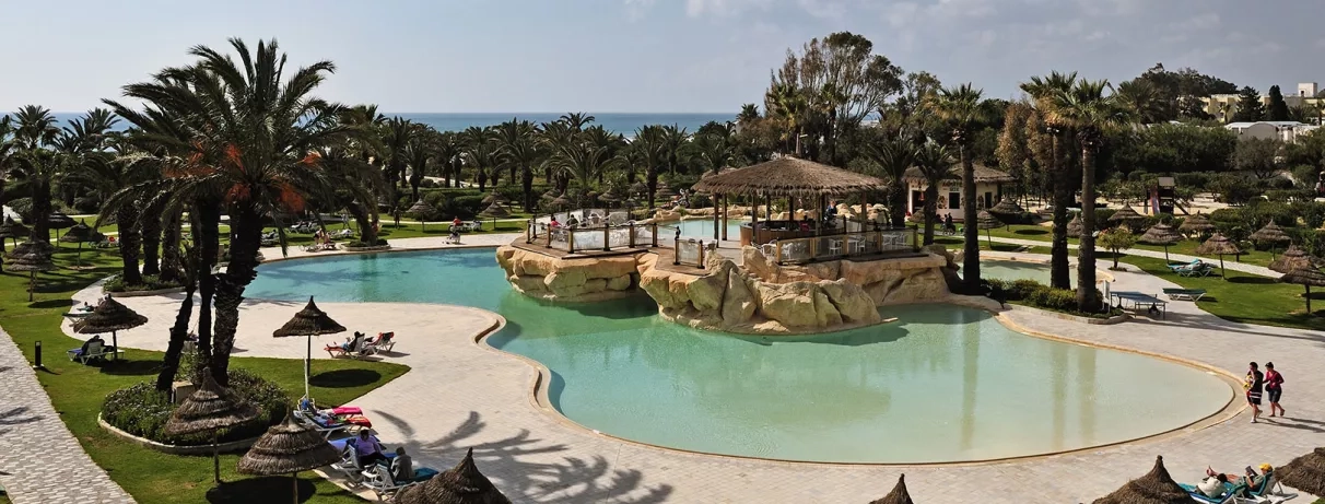 Piscine avec palmiers dans un cadre tropical