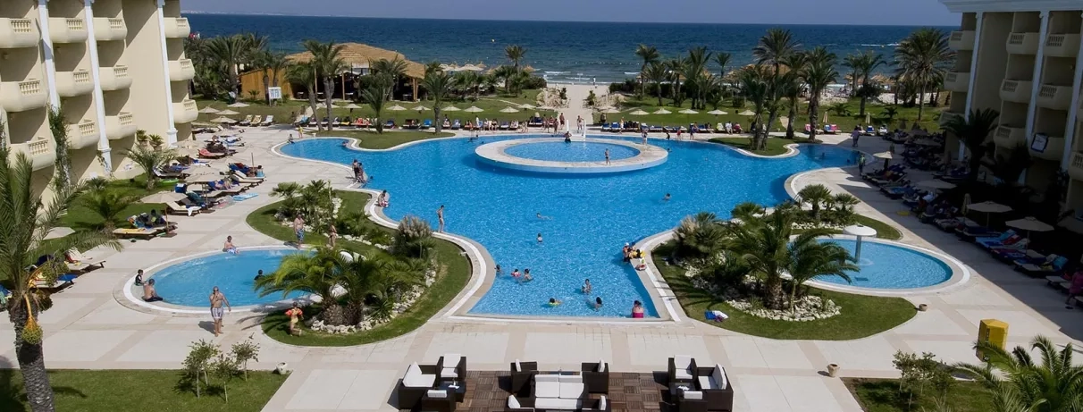 Vue panoramique sur les piscines extérieures et la plage privée du complexe hôtelier Royal Thalassa Monastir.