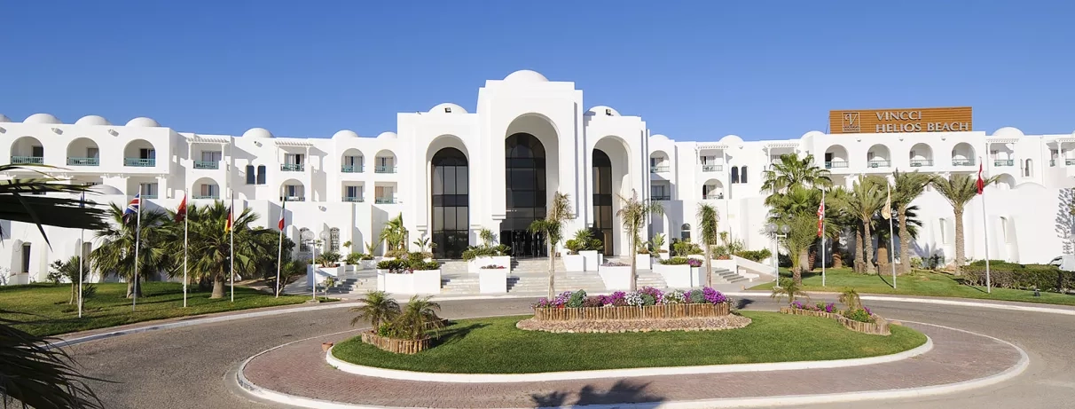 Entrée principale monumentale de l'hôtel Vincci Helios Beach entourée de jardins exotiques pour un voyage luxueux.