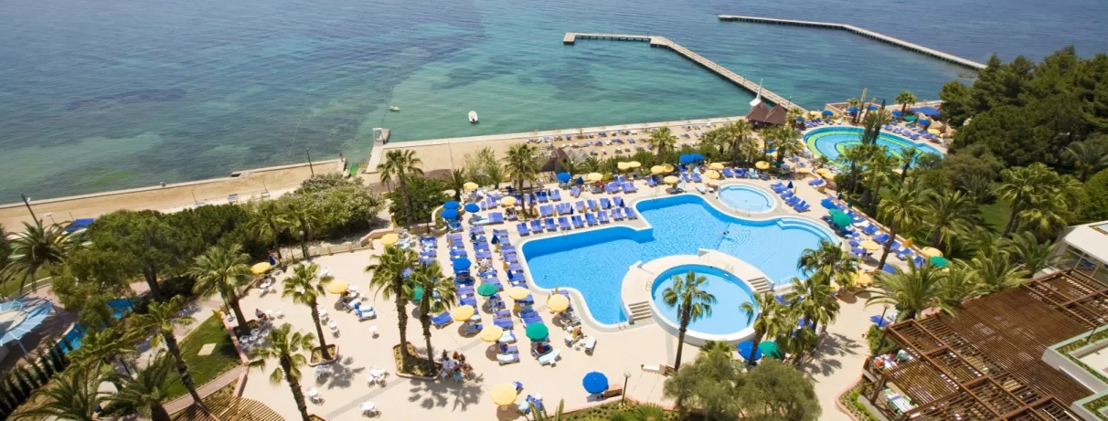 Une vue aérienne sur une grande piscine et un parc aquatique bordant la mer.