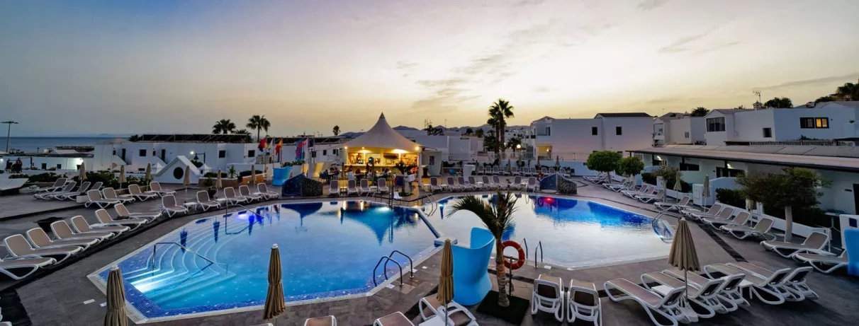 Une ambiance de fin de journée sur le complexe où les lumières du bar central commencent à briller.