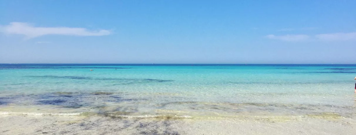 Vue panoramique de l'eau cristalline et du sable fin sur la plage privée du Seabel Rym Beach.