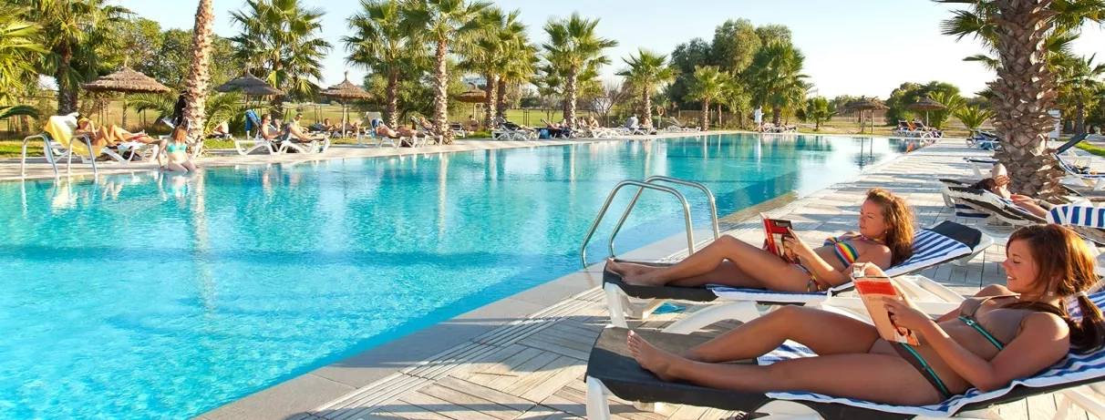 2 femmes sur transats devant piscine