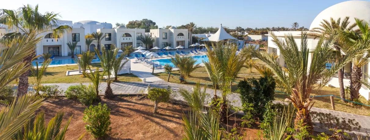 Vue sur les piscines extérieures et l'architecture typique du complexe hôtelier César Thalasso à Djerba.