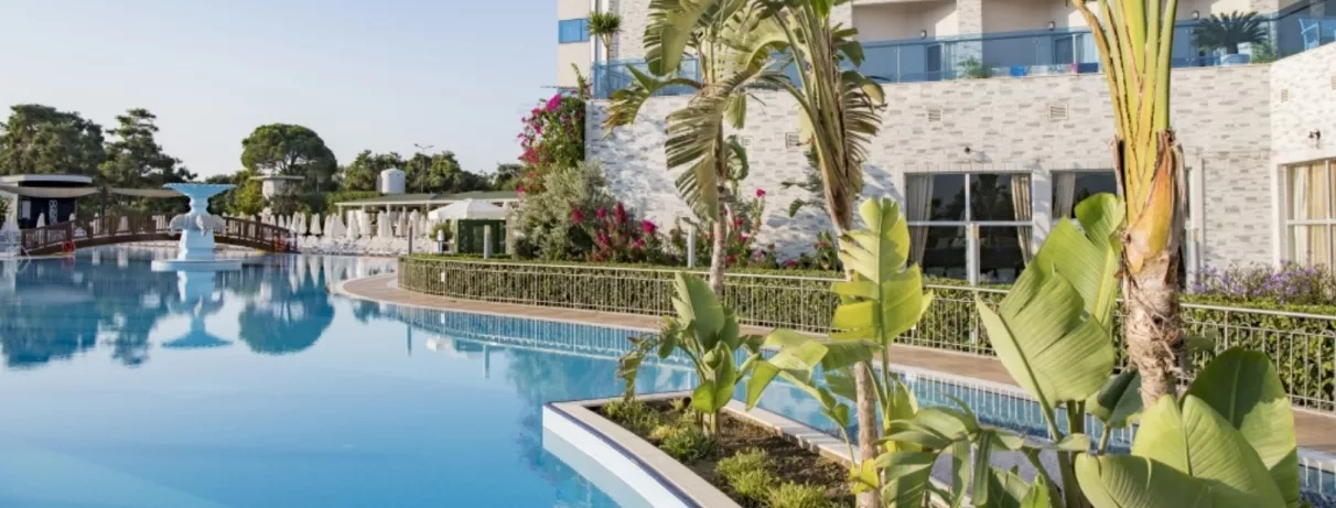 vue de la piscine extérieur et du jardin devant la façade de l'hôtel