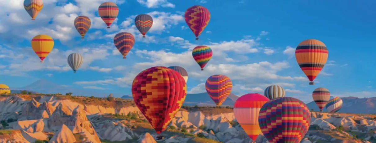 Un ciel remplis de montgolfières survolant les formations rocheuses uniques de la région.