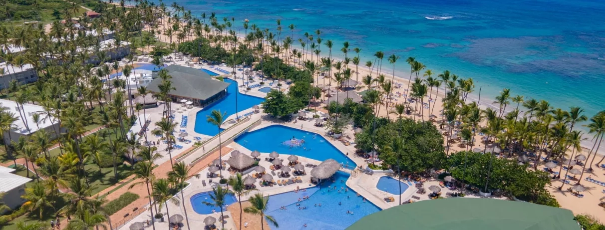 piscines, palmiers, transats, parasols, pieds dans l'eau, cocotiers, plage de sable