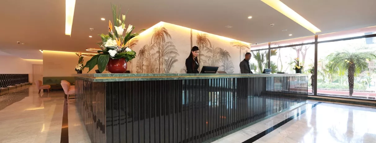 Réception de l'hôtel avec grand baie vitré donnant sur le jardin