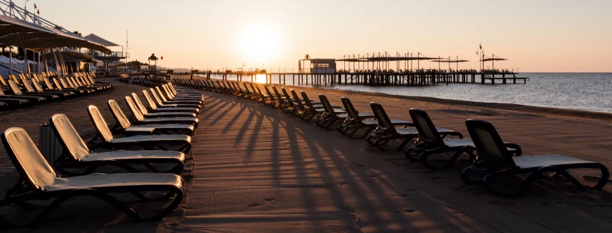 plage avec transats avec le coucher du soleil