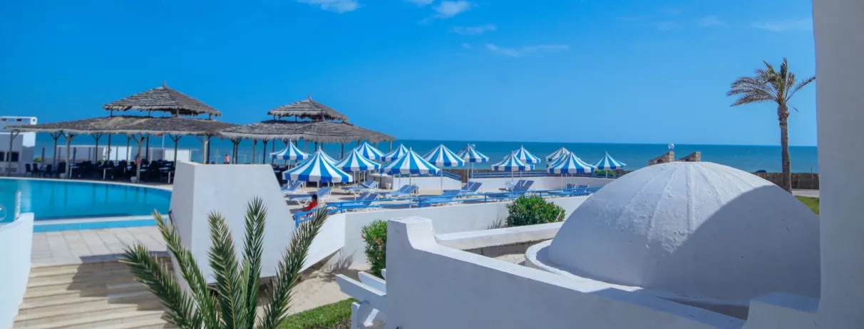Toits en coupole blancs, parasols rayés et vue sur mer Méditerranée depuis le complexe Al Jazira Djerba.