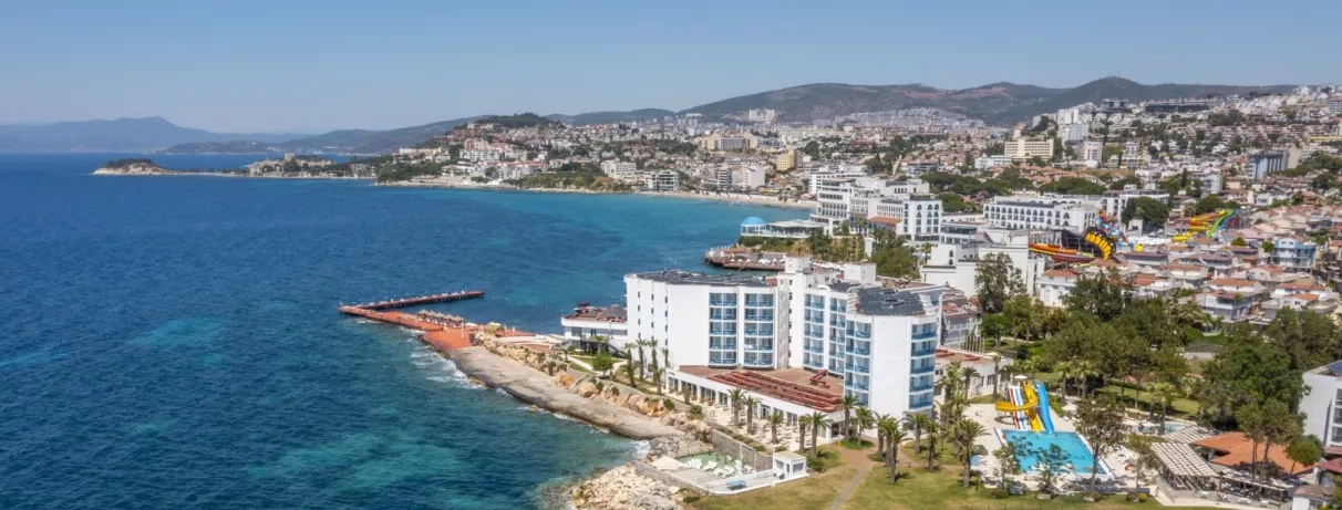 Un panorama côtier surplombant une ville balnéaire et ses grands hôtels en bord de mer.