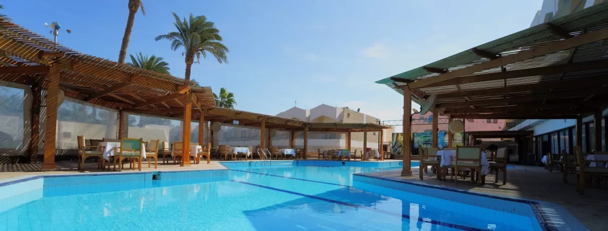 vue restaurant au bord de la piscine extérieur avec palmiers