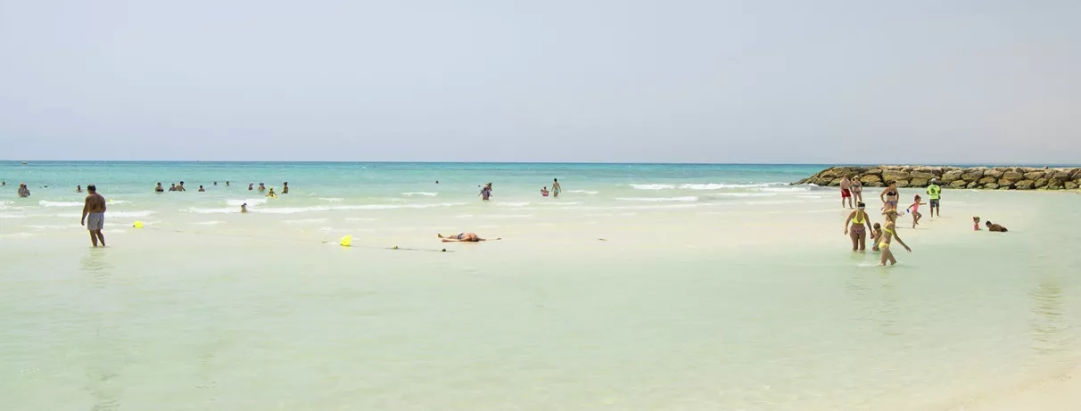 Baignade en eau peu profonde sur la plage privée de l'hôtel Mondi Club Seabel Aladin Djerba.