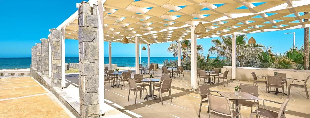 restaurant sur la plage, tables et chaises, vue sur la mer, végétation, luminaires