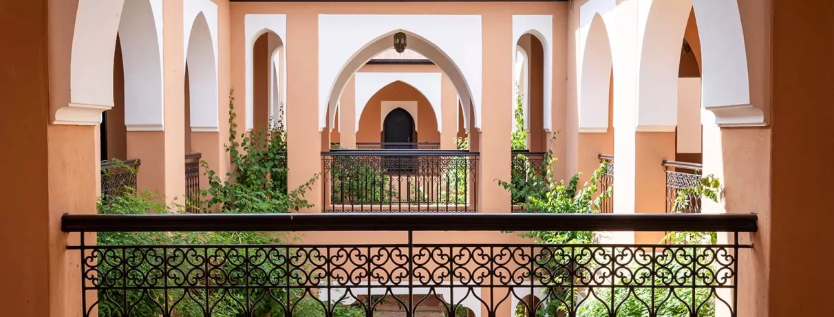 Patio dans le bâtiment des chambres avec une fontaine au milieu et des végétations au coin