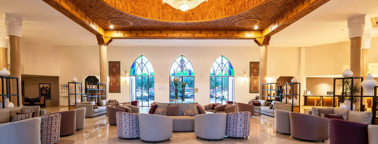 Réception de l'hôtel avec des chaises en beige et un toit sculpté oriental bien décoré