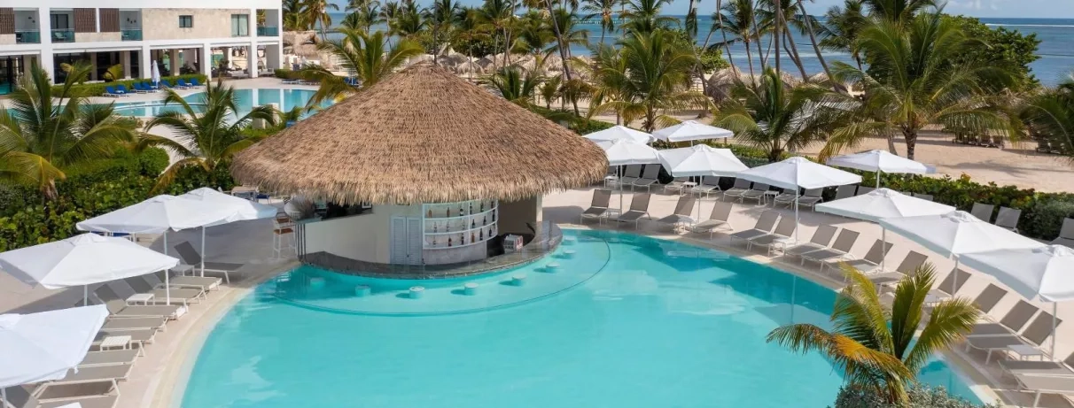 Pool bar, transats et parasols, pieds dans l'eau, palmiers