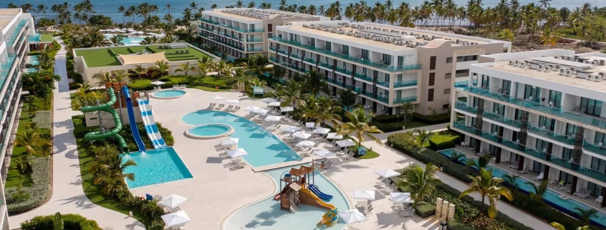 hôtel, plusieurs piscines, palmiers, transats, parasols, bord de mer, aquapark, toboggans