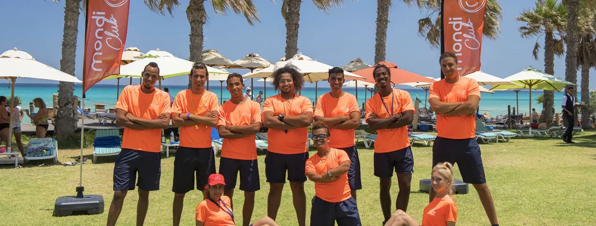 Groupe d'animateurs représentant mondial tourisme posant devant les transats