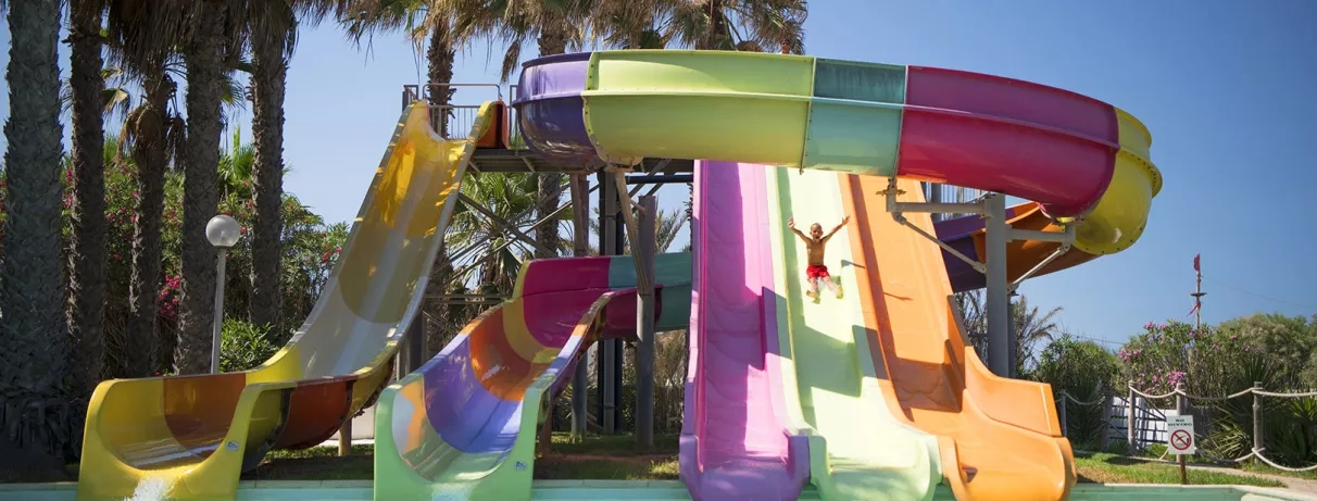Parc aquatique équipé de cinq toboggans, avec un enfant qui s’amuse joyeusement