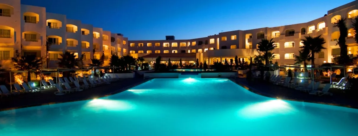 Vue de la piscine extérieure et du bâtiment de l'hôtel de nuit