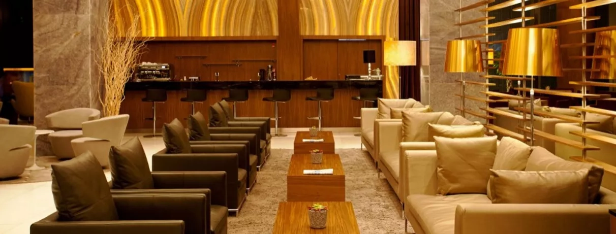 hall de l'hôtel avec bar et coin salon avec canapés et fauteuils