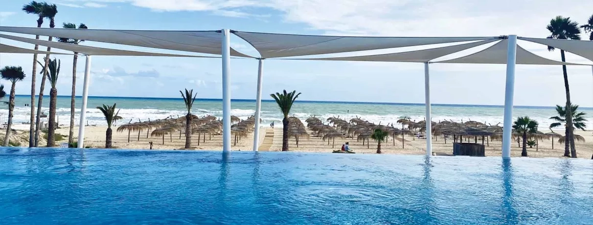 piscine extérieure avec vue sur la plage équipée de transats 
