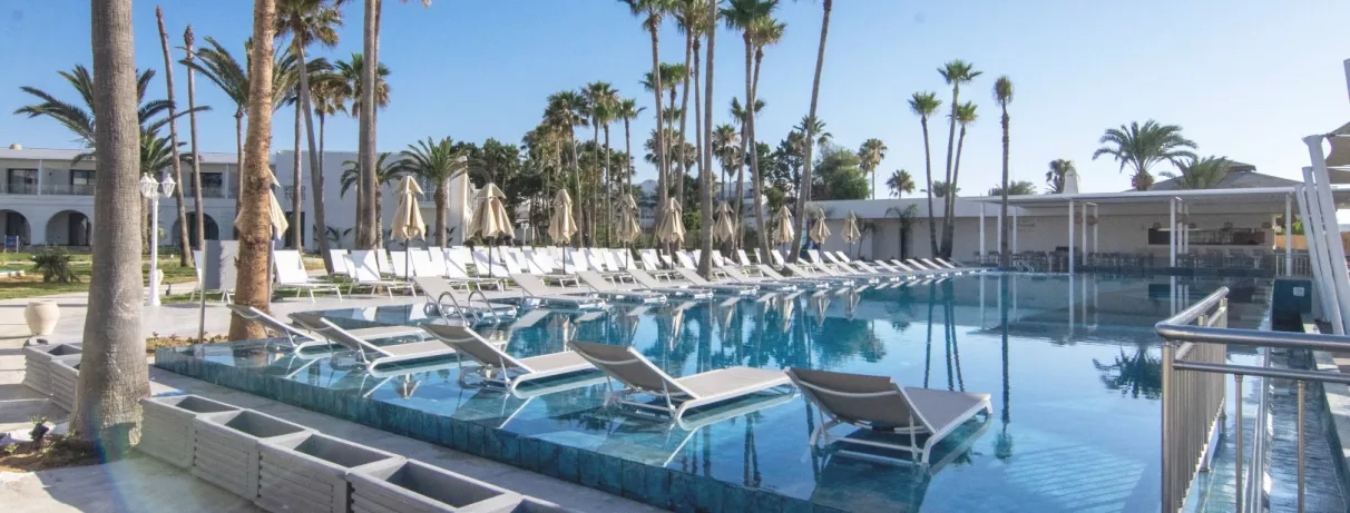 piscine extérieure avec transats et palmiers 