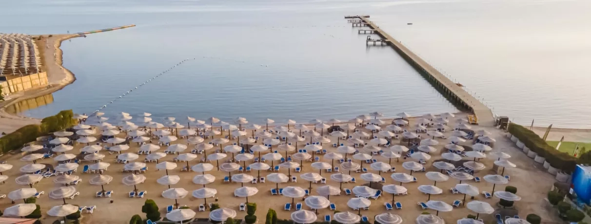 vue d'ensemble parasols, transats, au bord de la plage avec sable fin
