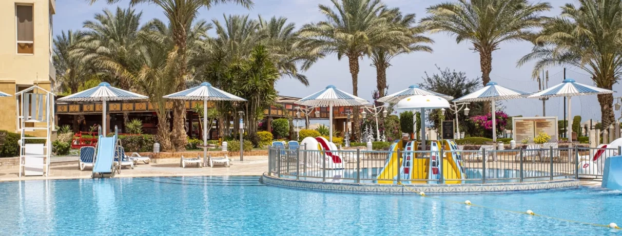 piscine extérieure avec toboggans, transats, parasol, soleil