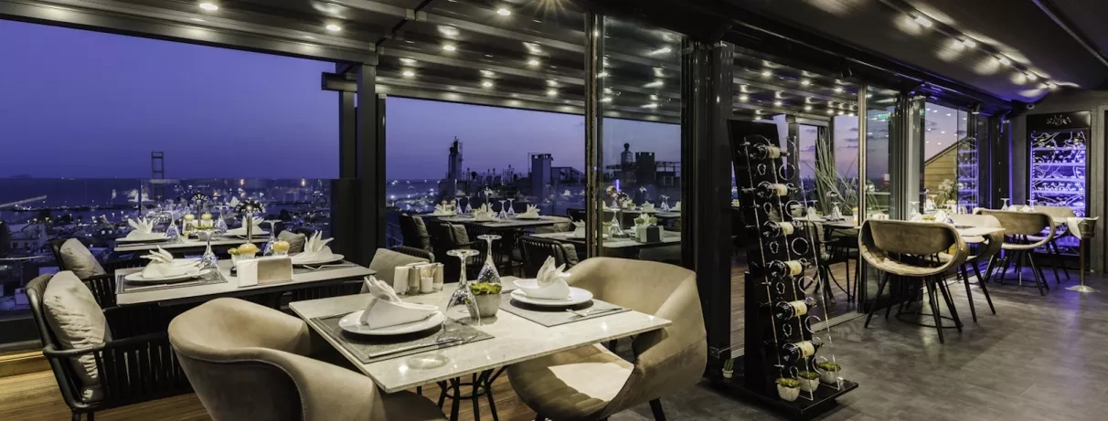 salle de restaurant avec vue de nuit sur la ville