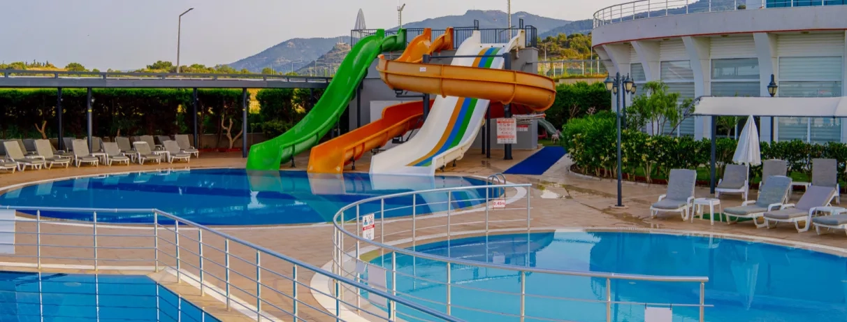 Un parc aquatique avec plusieurs toboggans se jetant dans une piscine rafraîchissante.
