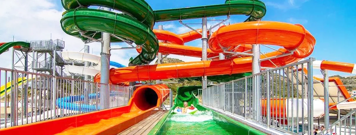 toboggans orange et vert avec femme qui se baigne au milieu et des barres pour la sécurité 