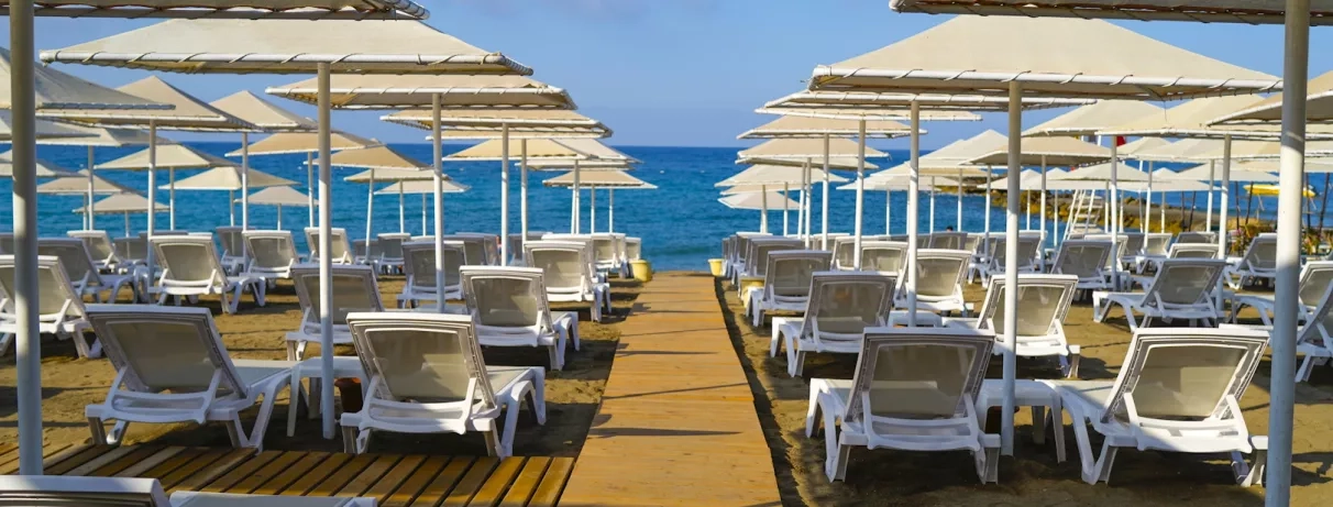 transats et parasols sur la plage et en fond la mer