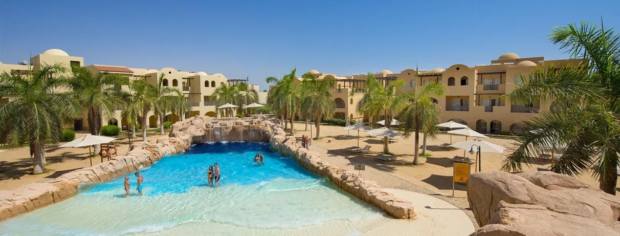 Piscine à vagues artificielle entourée de bâtiments orientaux et transats au resort 5 étoiles à Hurghada, Égypte.