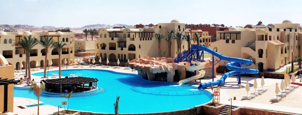 Parc aquatique avec toboggans bleus et bar de piscine au Mondi Club Stella Gardens, Hurghada, Égypte.