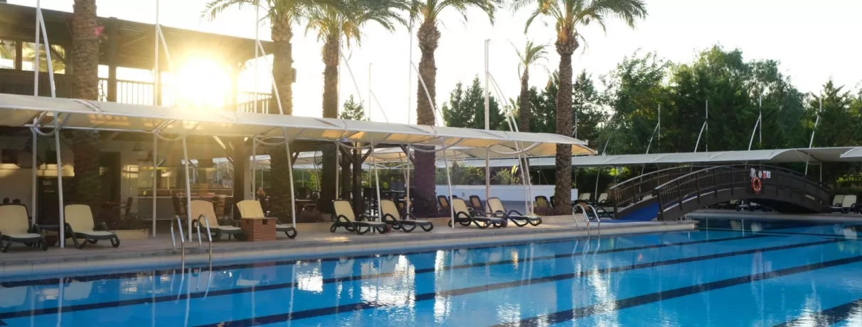 vue de la piscine extérieure de l'hôtel avec coucher de soleil