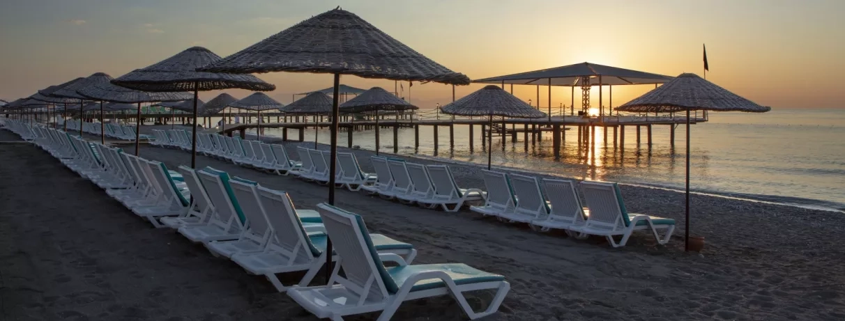 vue au coucher de soleil de la plage avec transats et parasols 