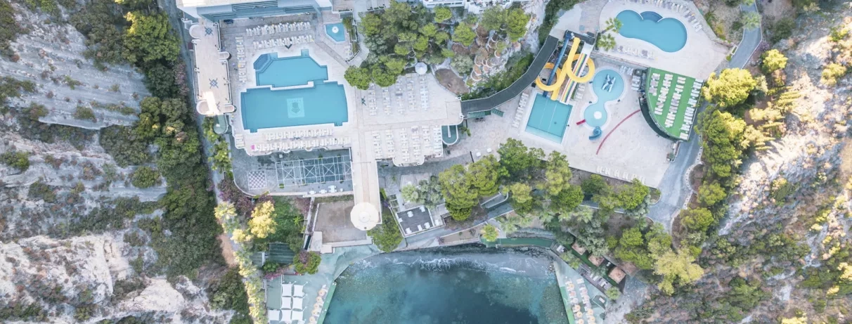 Une vue aérienne centrée sur les différentes piscines et les aménagements paysagers de l'hôtel.